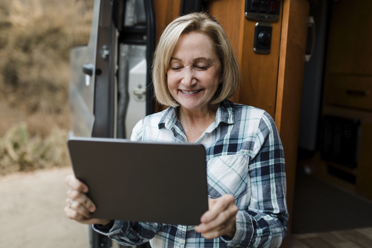 Grandma sitting in camper van while looking at his tablet